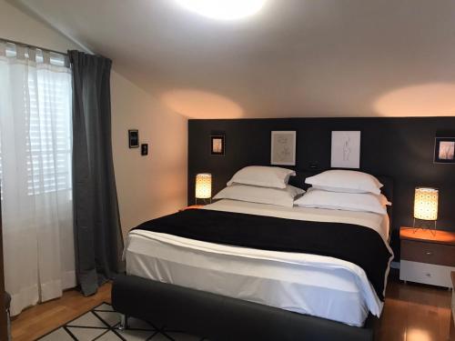 a bedroom with a large bed with a black headboard at Apartments Sax in Crikvenica