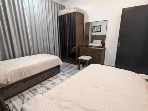 a hotel room with two beds and a mirror at Wadha Luxury Apartment in Al Khobar