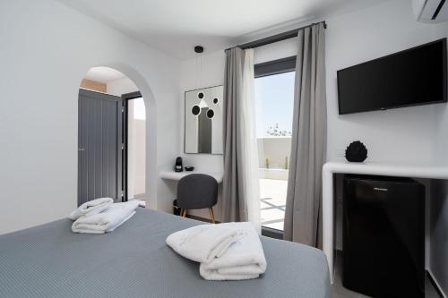 a bedroom with a bed with two white towels at LyMaRou Collection in Megalokhori