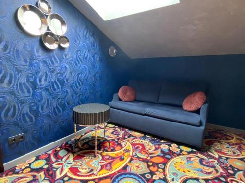a blue room with a couch and a colorful carpet at ArtApart Vozdvigenka in Kyiv