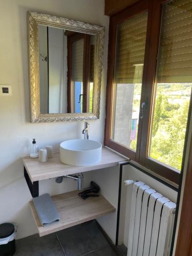 a bathroom with a sink and a mirror and a radiator at Leyendas Del Pirineo in Fiscal