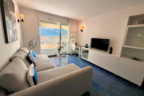un salon avec un canapé et une télévision dans l'établissement Golfe Juan - 4 People - Sea View - Swimming Pool - Garage, à Vallauris