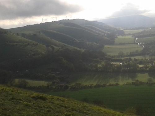 a view of a green valley with a river on a hill at B&B South Downs Way in Poynings