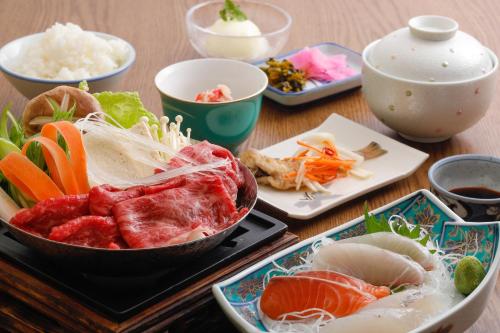 a wooden table with plates of food on it at Tsuruya Ryokan in Toyooka