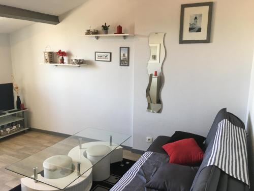 un salon avec un canapé et une table en verre dans l'établissement Studio Vue Port, à La Rochelle