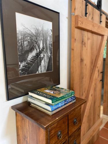 a stack of books on a dresser with a mirror at Guestlands Italia B&B in Arcadia