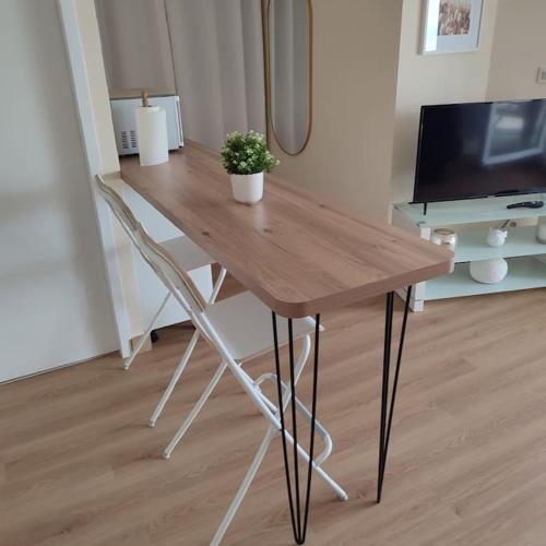 a wooden table with two chairs and a television at Vue Panoramique FACE MER in Bray-Dunes