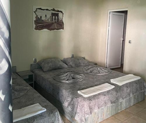 a bedroom with a large bed with towels on it at Комплекс Дворъ in Varna City