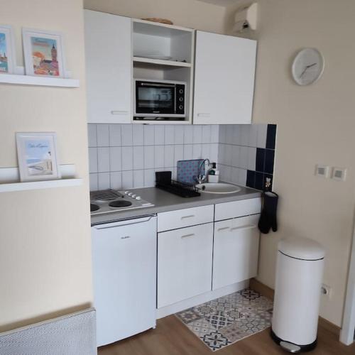 a white kitchen with a sink and a microwave at Vue Panoramique FACE MER in Bray-Dunes