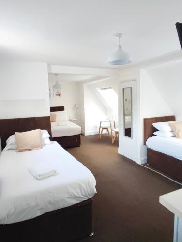a hotel room with two beds and a table at Central Wave in Brighton & Hove