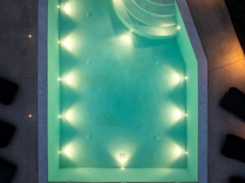 a swimming pool with lights in a room at LyMaRou Collection in Megalokhori