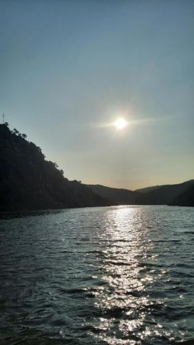 a sun setting over a body of water at Ferradosa GuestHouse in São João da Pesqueira