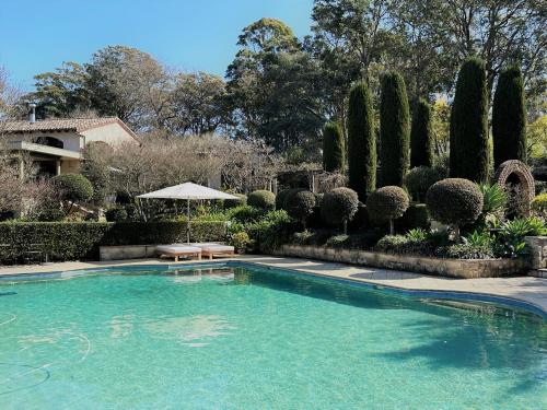 a swimming pool in a yard with trees and a house at Guestlands Italia B&B in Arcadia