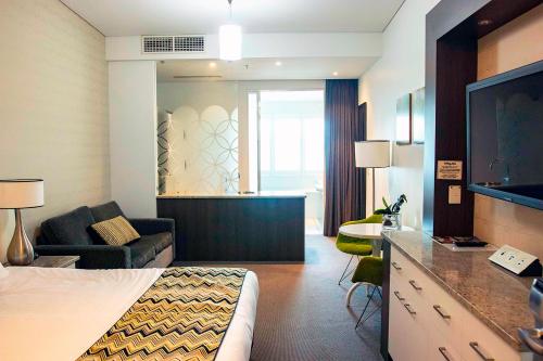 a hotel room with a bed and a living room at Walkers Arms Hotel in Adelaide