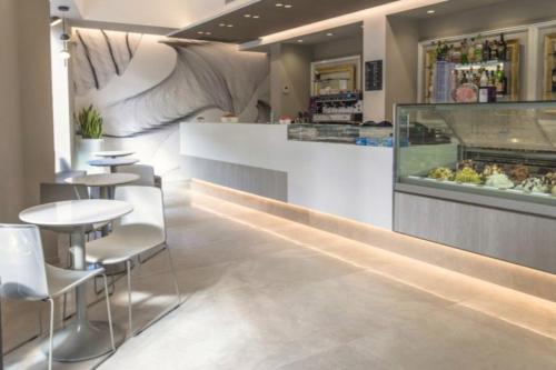 a restaurant with a counter and tables and chairs at Vicolo Fiore Affittacamere II in Matera