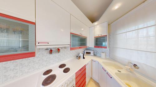 a kitchen with white cabinets and a sink at Raise Riviera Panoramic Sea View apartment in Athens
