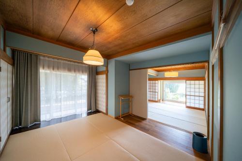 an empty room with wooden ceilings and a large window at 白浜レジデンス 1日1組限定 ファミリー向け 炭火焼イタリアンディナー付き in Minamiboso