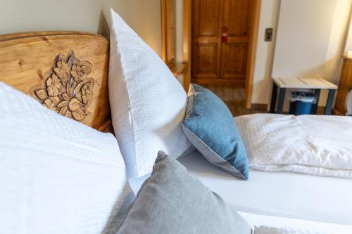 a white bed with pillows on it in a room at Landgasthof & Brauerei Löwen Sasbach in Sasbach in der Ortenau