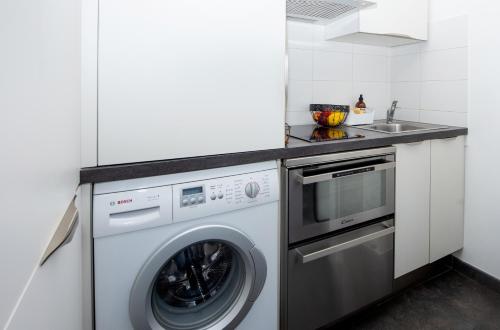 une cuisine avec une machine à laver et un évier dans l'établissement Appartement vue mer, à Cagnes-sur-Mer
