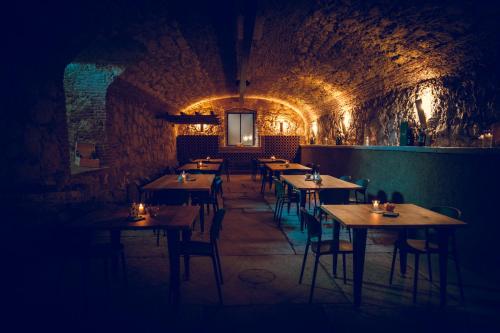 a restaurant with wooden tables and chairs in a tunnel at VerdeOlivo 1876 - Apartments & Pool in Mezzane di Sotto