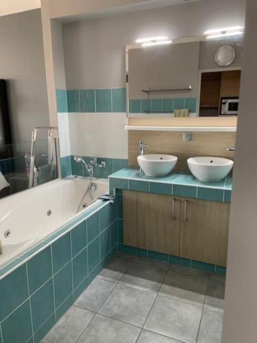 une salle de bain avec deux lavabos et une baignoire dans l'établissement Jardin d eden village naturiste, au Cap d'Agde