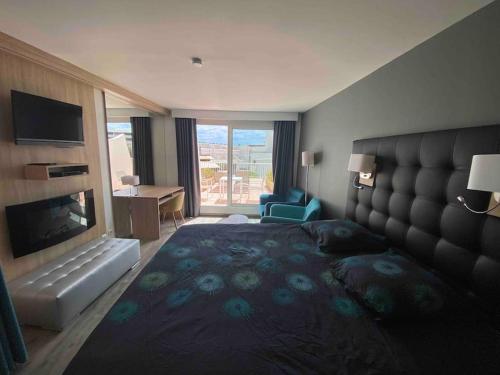 Cette chambre comprend un grand lit et une cheminée. dans l'établissement Jardin d eden village naturiste, au Cap d'Agde