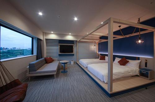 a bedroom with a canopy bed and a couch at Spa World HOTEL&RESORT in Osaka
