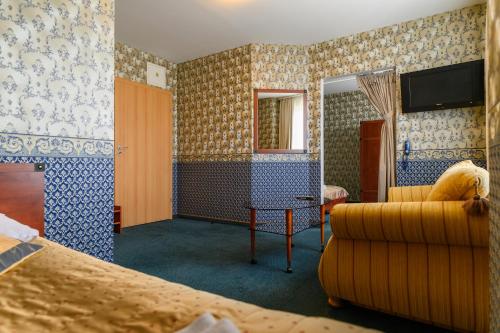 Habitación de hotel con sofá y espejo en Synet CoLiving, en Mažeikiai