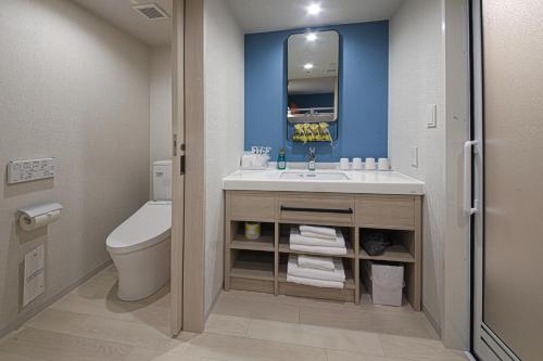 a bathroom with a sink and a toilet at Spa World HOTEL&RESORT in Osaka