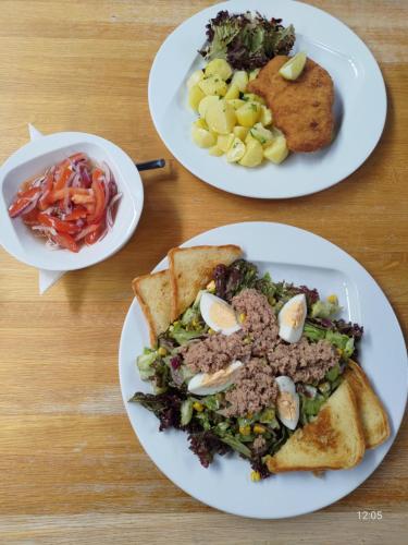three plates of food on a wooden table at Pivotel MMX in Dobřichovice