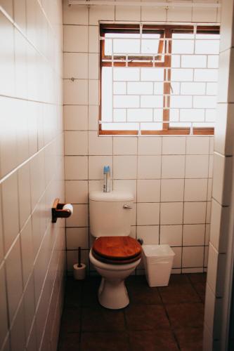 a bathroom with a toilet with a wooden seat at Laaiplek Hotel in Velddrif