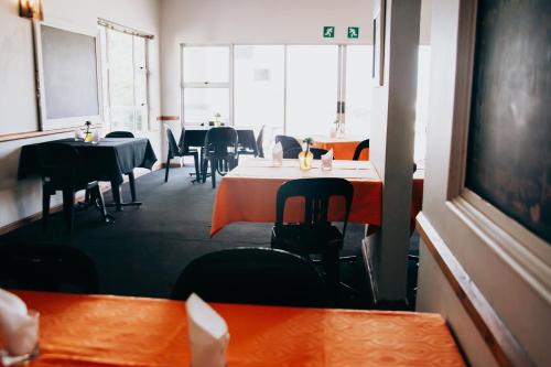 a dining room with tables and chairs and a chalkboard at Laaiplek Hotel in Velddrif