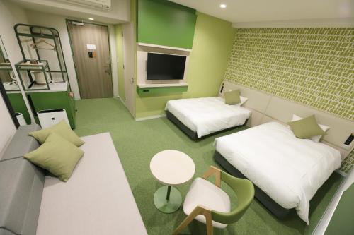 a hospital room with two beds and a couch at Spa World HOTEL&RESORT in Osaka