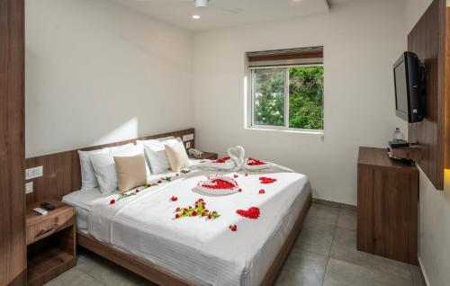 a bedroom with a bed with red flowers on it at Green Tea Hotels in Devikolam