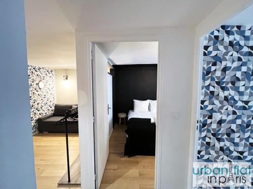 un couloir menant à une chambre avec un lit dans l'établissement Urban Flat 89 - Charming 3 Bedroom Flat in Paris, à Paris
