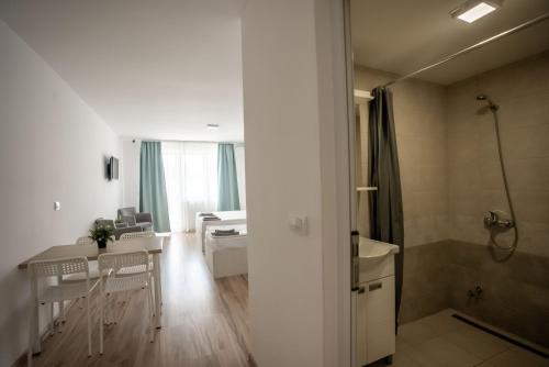 a white bathroom with a shower and a sink at Smeštaj Milutinn in Soko Banja