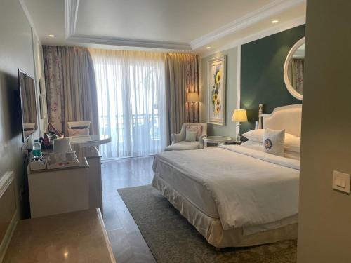 a bedroom with a large bed and a living room at Welcomhotel by ITC Hotels, The Savoy, Mussoorie in Mussoorie