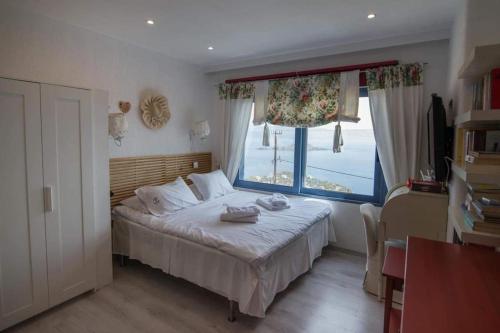 a bedroom with a bed with a large window at White-Blue Luxury Villa 2 in Pefkali