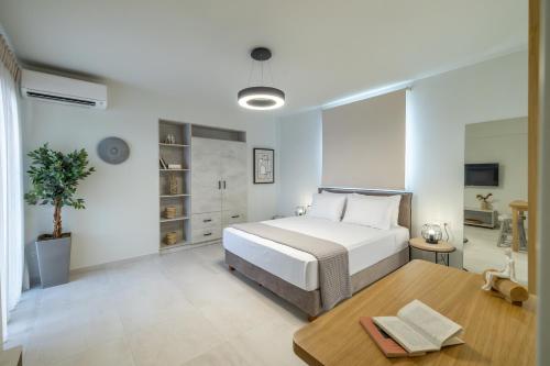 a white bedroom with a bed and a table at One Bedroom Apartment Erato in Argostoli