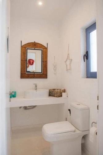 a white bathroom with a toilet and a sink at White-Blue Luxury Villa 2 in Pefkali