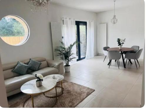 un salon avec un canapé et une table dans l'établissement Très belle maison lac d Enghien les bains 15 min Paris, à Saint-Gratien