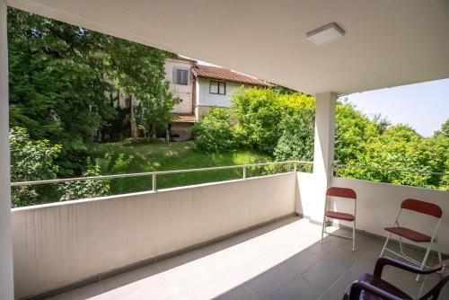 a balcony with two chairs and a view of a river at Smeštaj Milutinn in Soko Banja