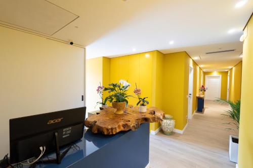 an office with yellow walls and a table with flowers on it at Hotel Ristorante Le Rose in Briatico
