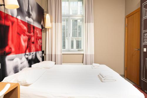 a bed in a room with a red and black wall at Ibis Riga Centre in Rīga