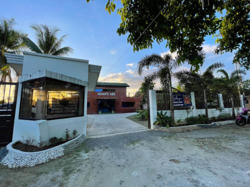 a store front with a building and palm trees at Noah's Ark Hotel powered by Cocotel in Dauis