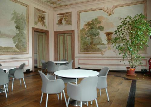 a room with tables and chairs and paintings on the walls at Villa Dragoni in Buttrio