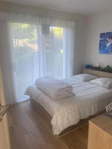 une chambre avec un lit et une grande fenêtre dans l'établissement Maison pour 4, Mer et marais salants, Spa, à Guérande