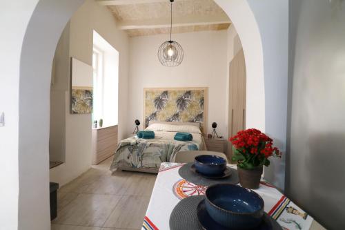 a bedroom with a bed and a table with bowls on it at Gardjola Apartment - Authentic Stay By the Marina, Ideal for Couples in Senglea