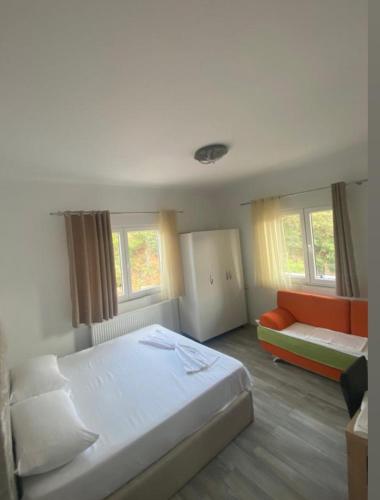 a bedroom with a bed and a couch and windows at Daniels Homestay in Lin