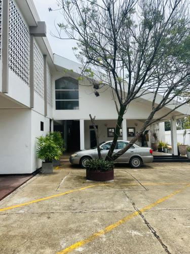 a car parked in a parking lot in front of a building at Beach Front by Kay Jay in Uswetakeiyawa